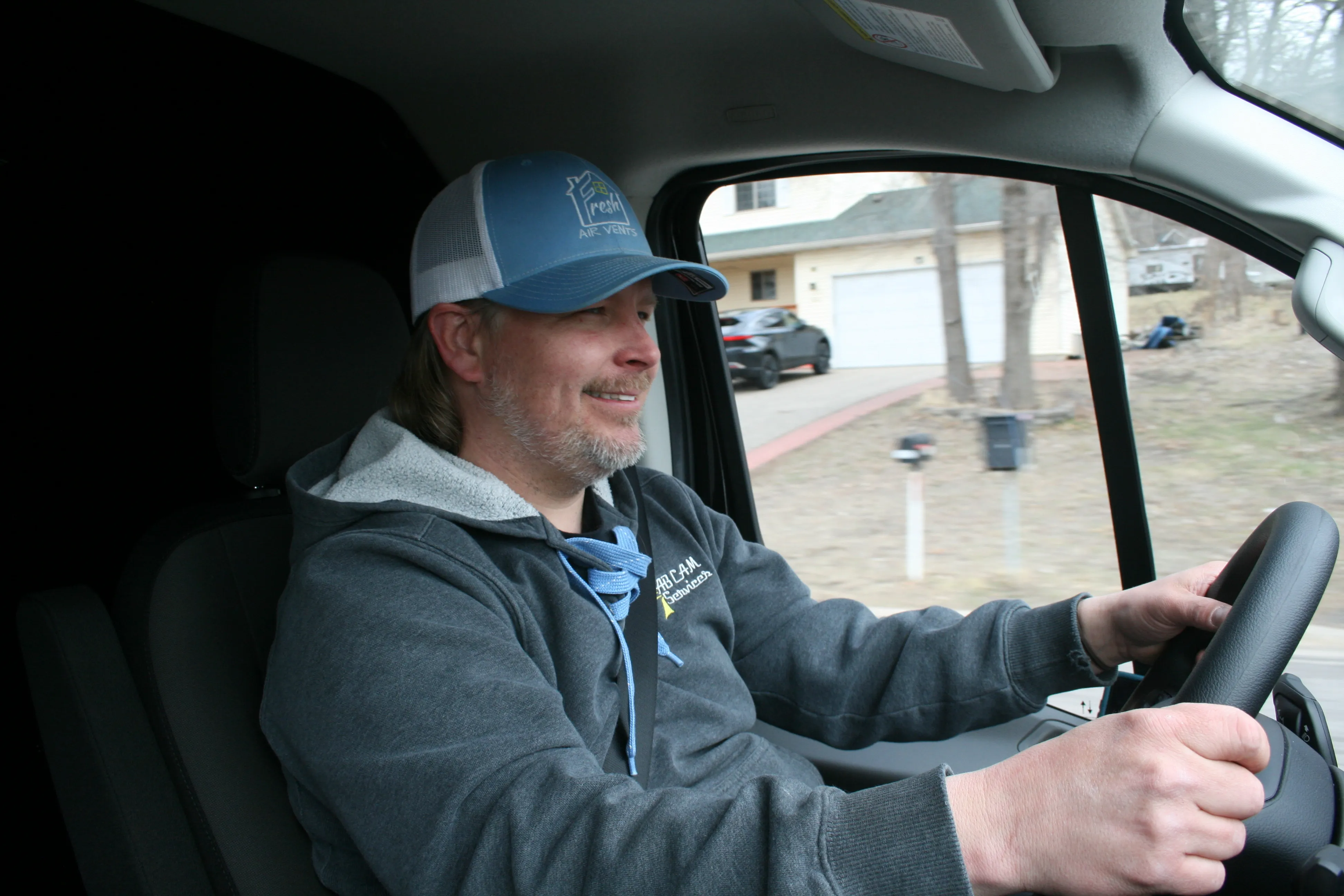 Owner Adam Bonine, wearing a Fresh Air Vents cap, on the way to a job